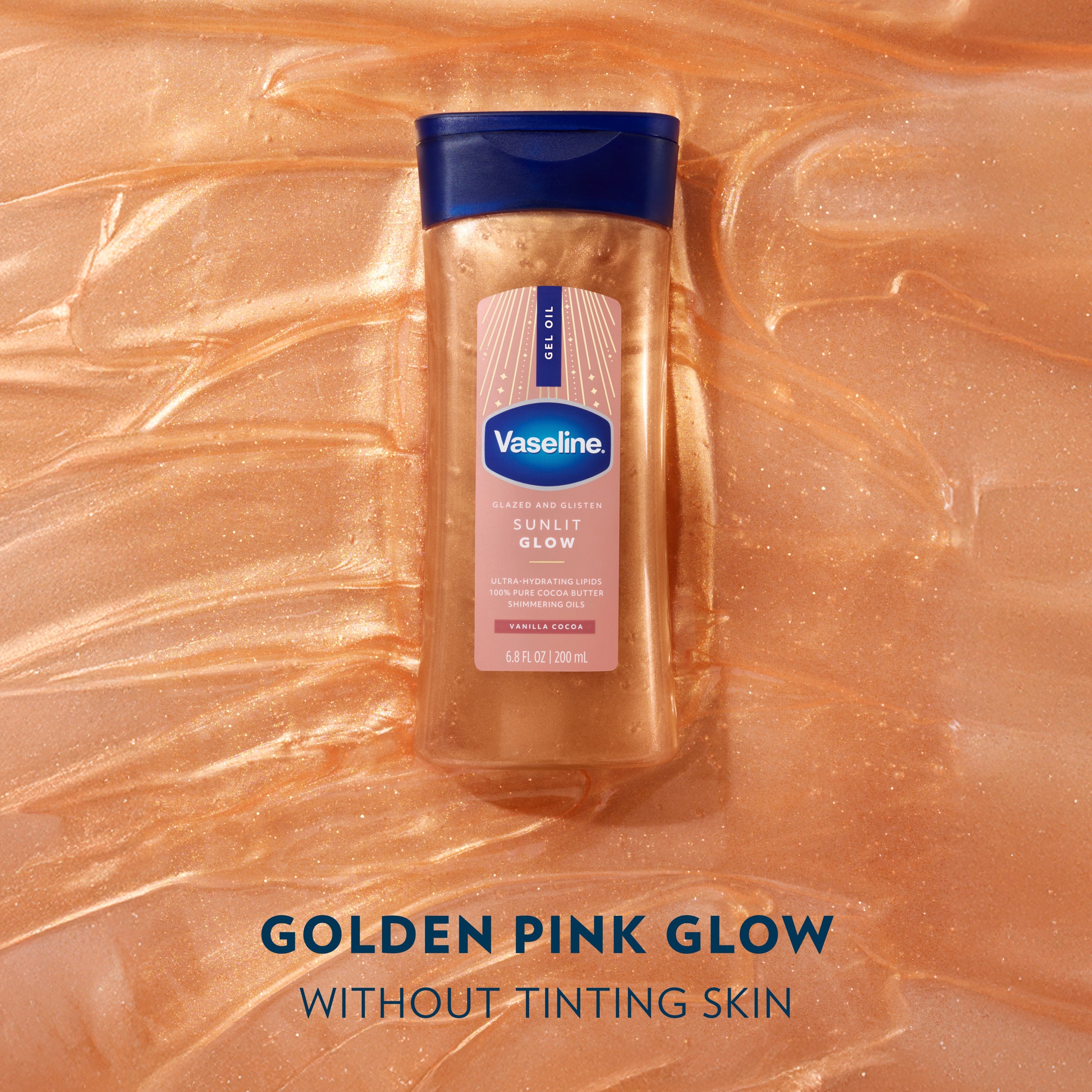 A bottle of Vaseline Sunlit Glow gel oil sits on a shimmering golden gel oil background with text