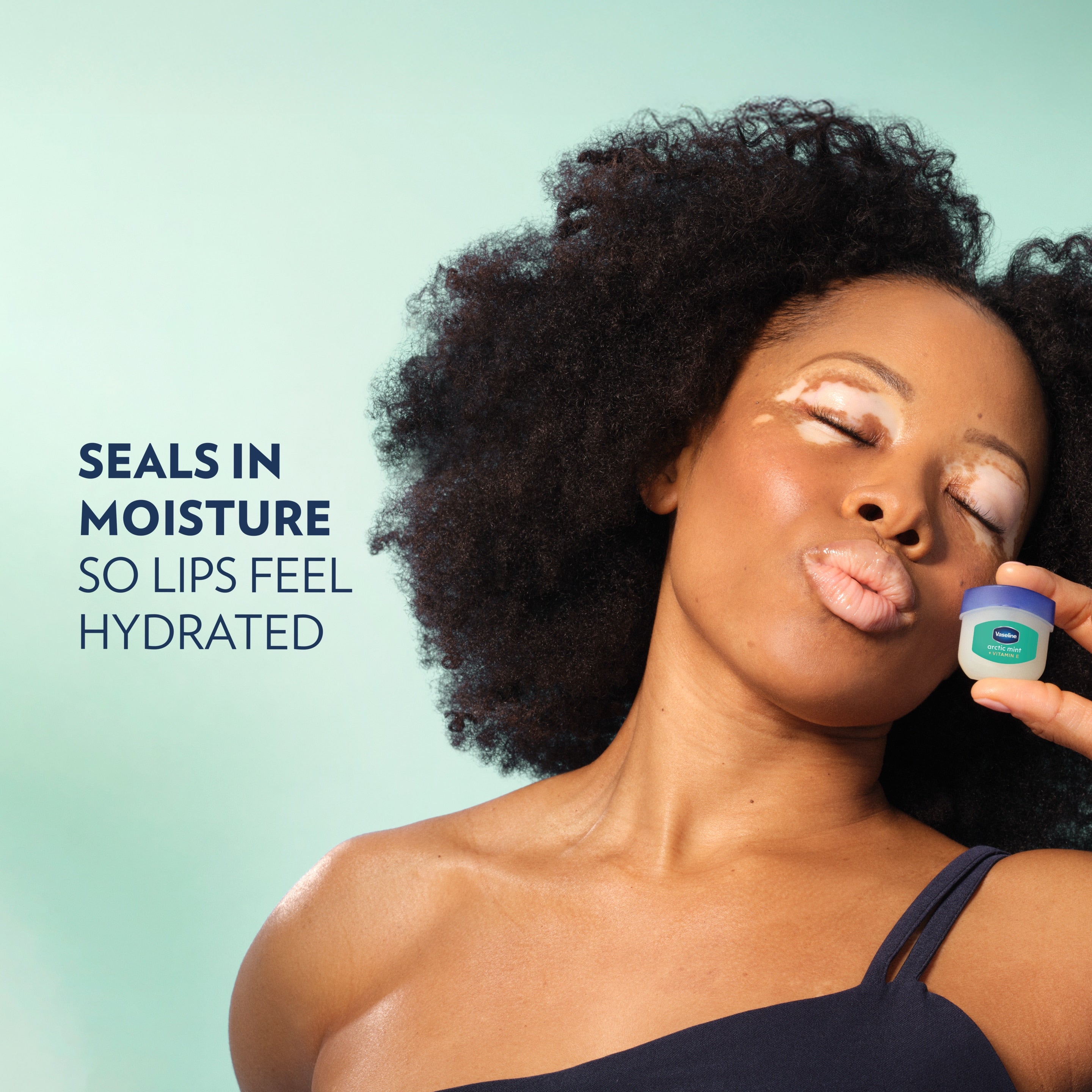A model holds up a Vaseline® Lip Therapy® Arctic Mint Mini next to her face