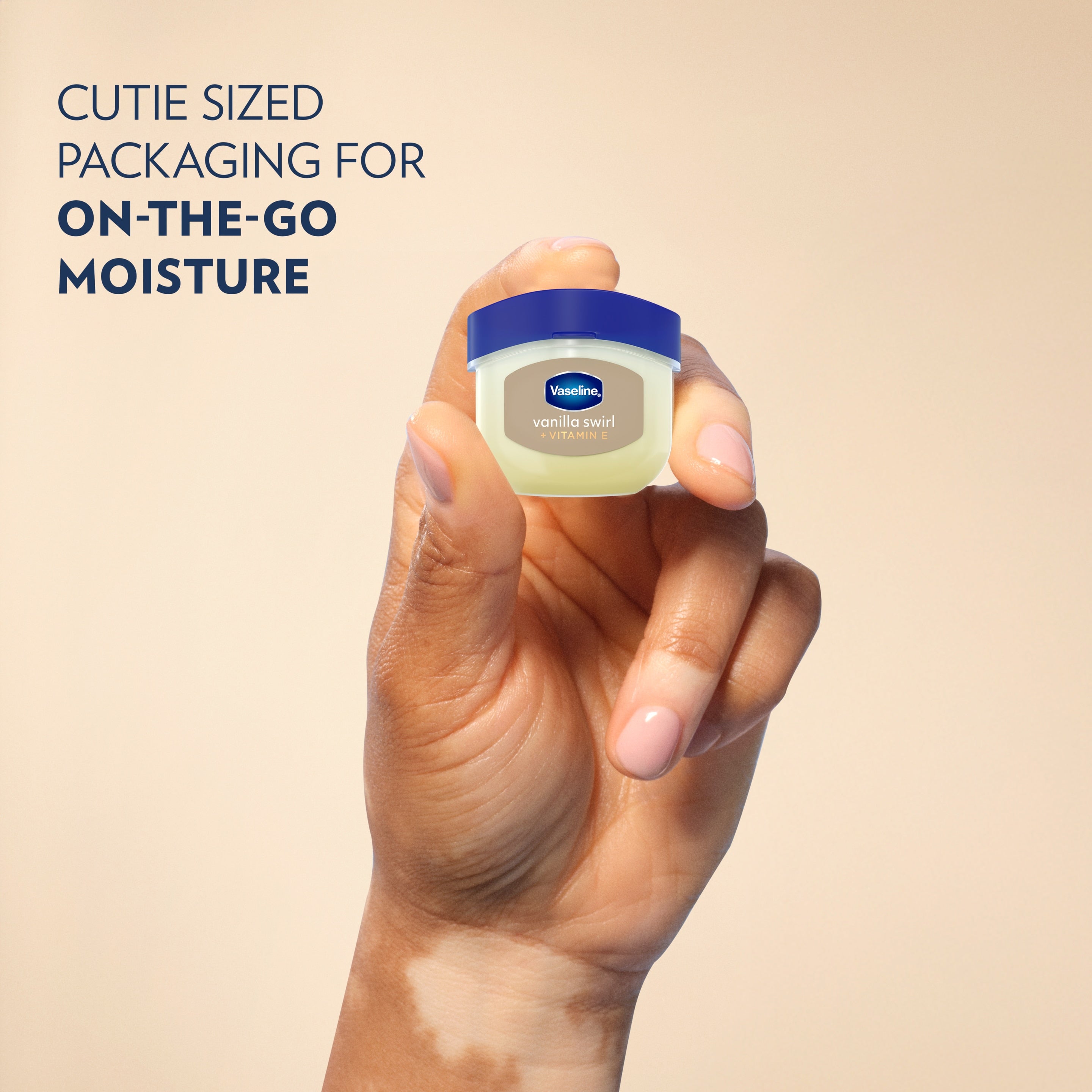 A hand holds a jar of Vaseline® Lip Therapy® Vanilla Swirl Mini next to text