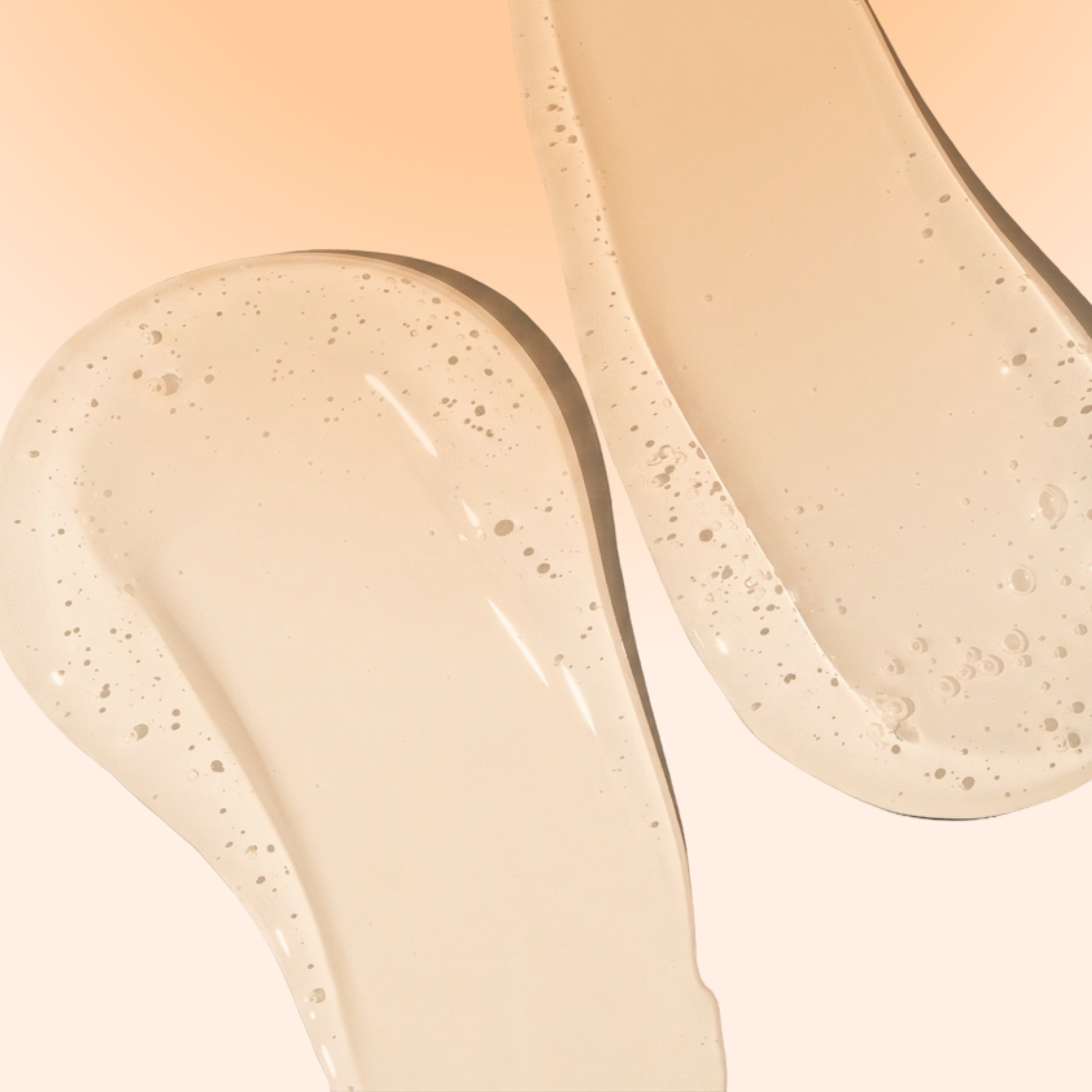 Close-up of two glossy gel oil swatches on a soft beige background